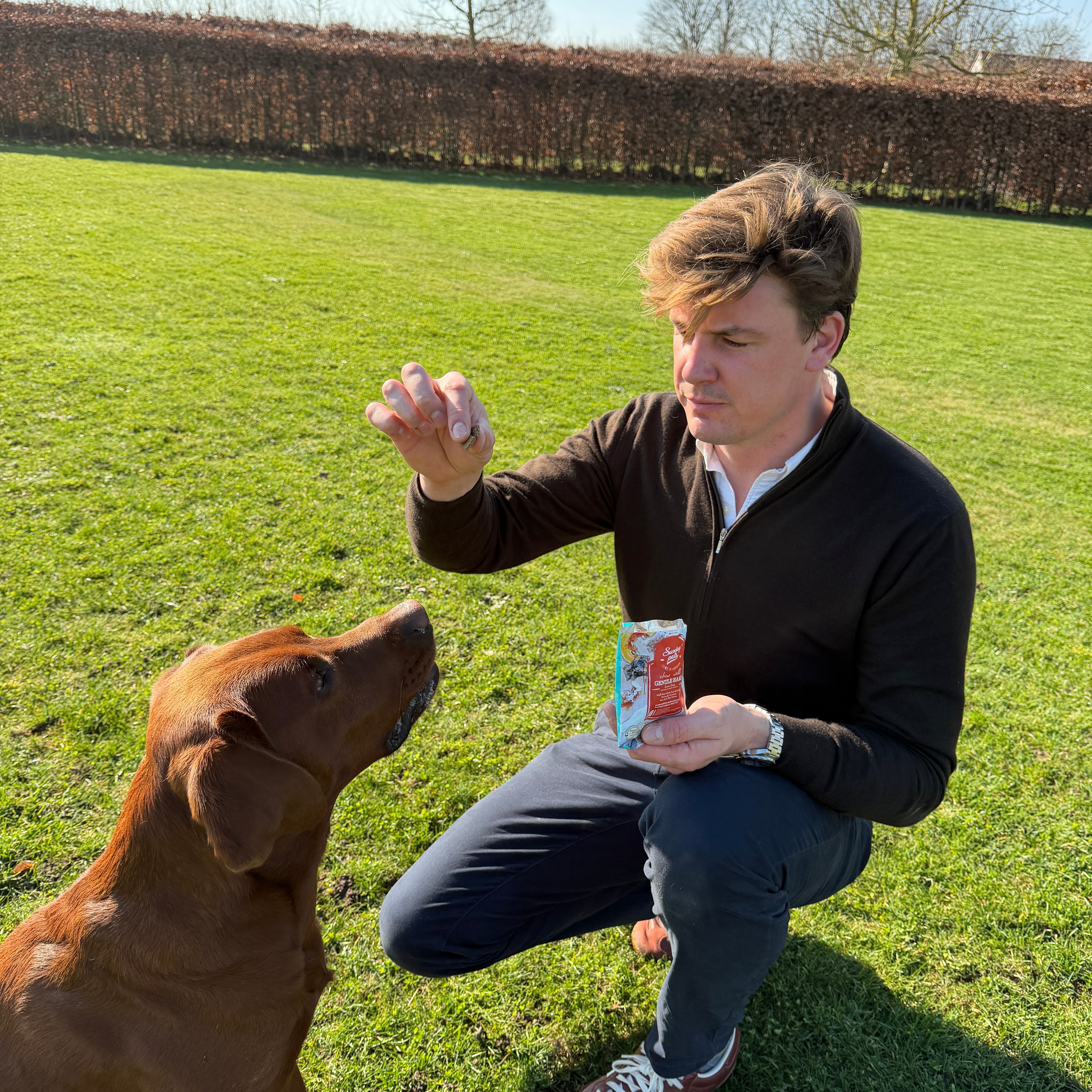 Man met bruine labrador geeft sundaypets hondensnacks
